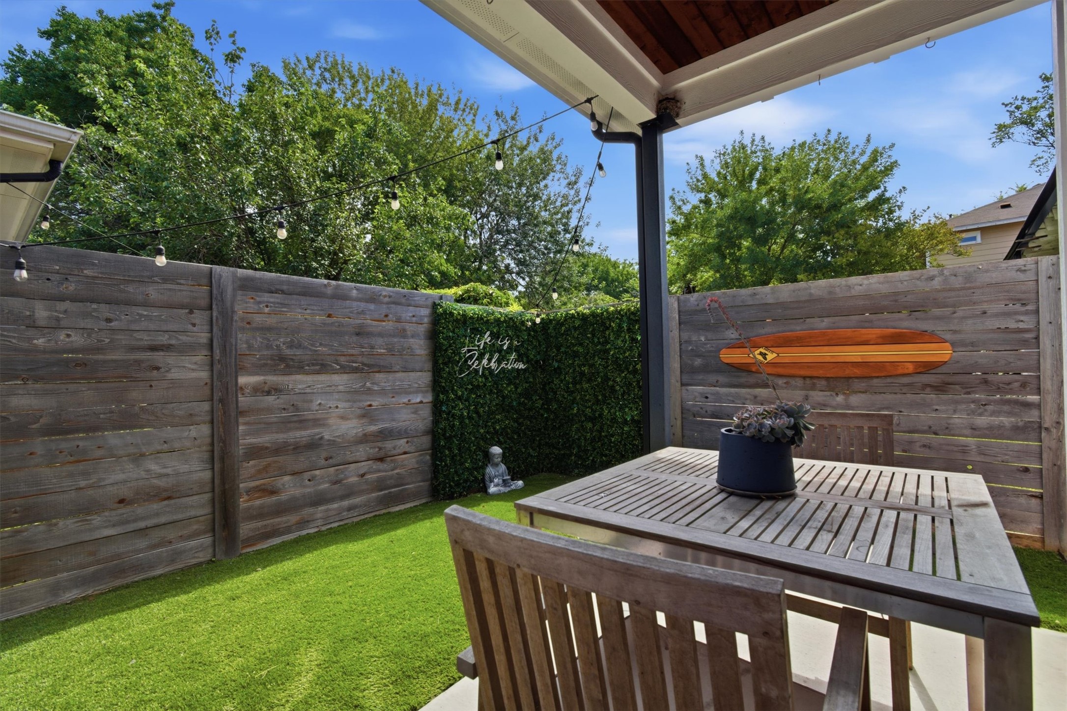 2710 Zaragosa Street, Unit A Austin, TX 78702 - Photo 27 of 29 Private fenced backyard with a covered patio and turf lawn — low-maintenance outdoor living off the main floor.