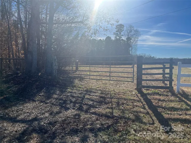 a view of a yard with wooden fence