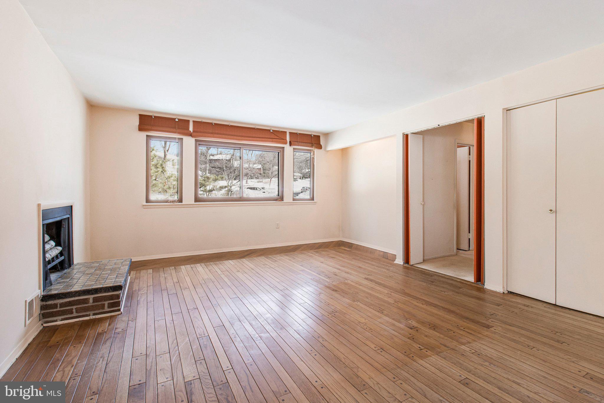 14816 Stonegate Terrace Silver Spring, MD 20905 - Photo 23 of 79 an empty room with wooden floor a ceiling fan and windows