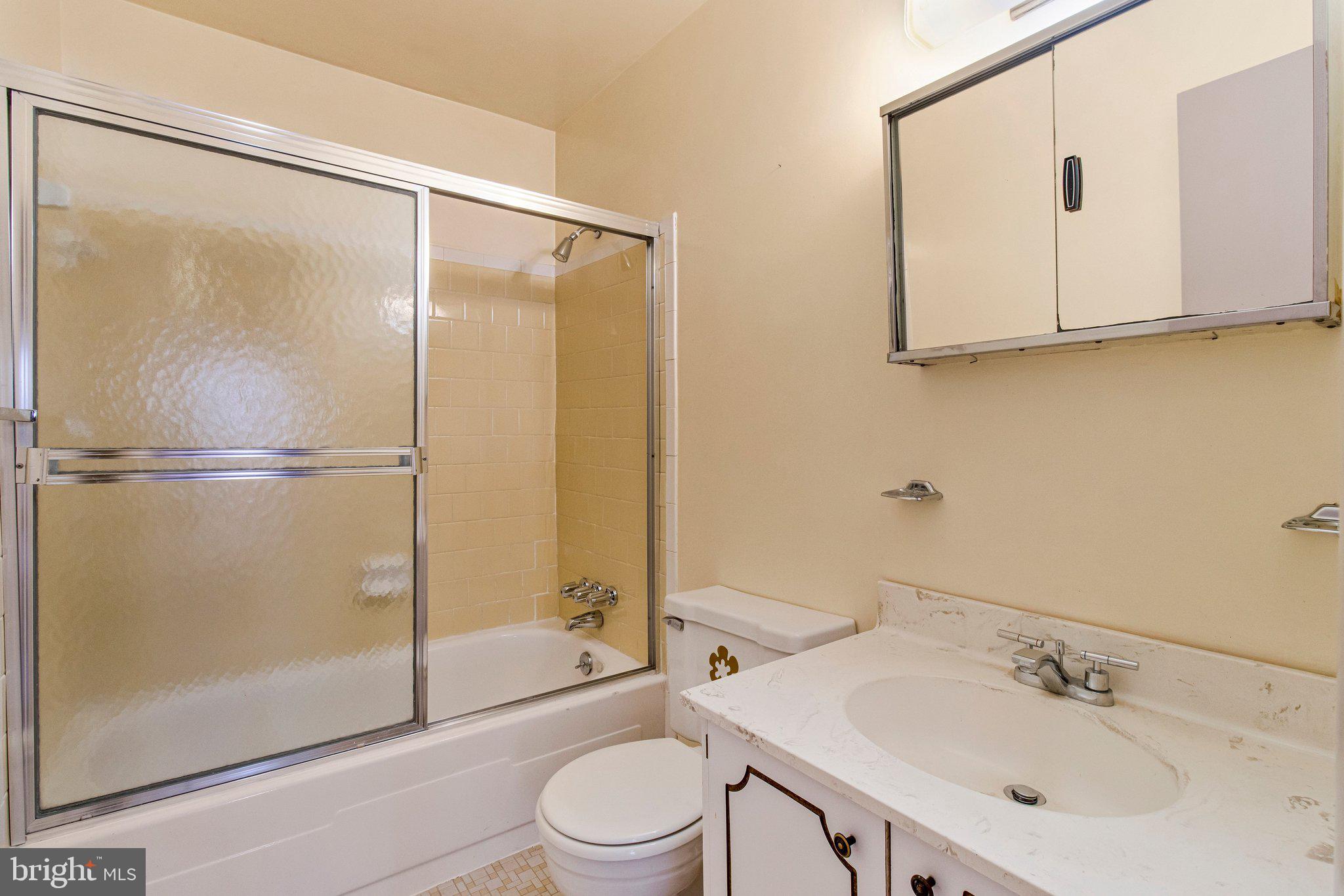 14816 Stonegate Terrace Silver Spring, MD 20905 - Photo 36 of 79 a bathroom with a shower sink vanity mirror and toilet