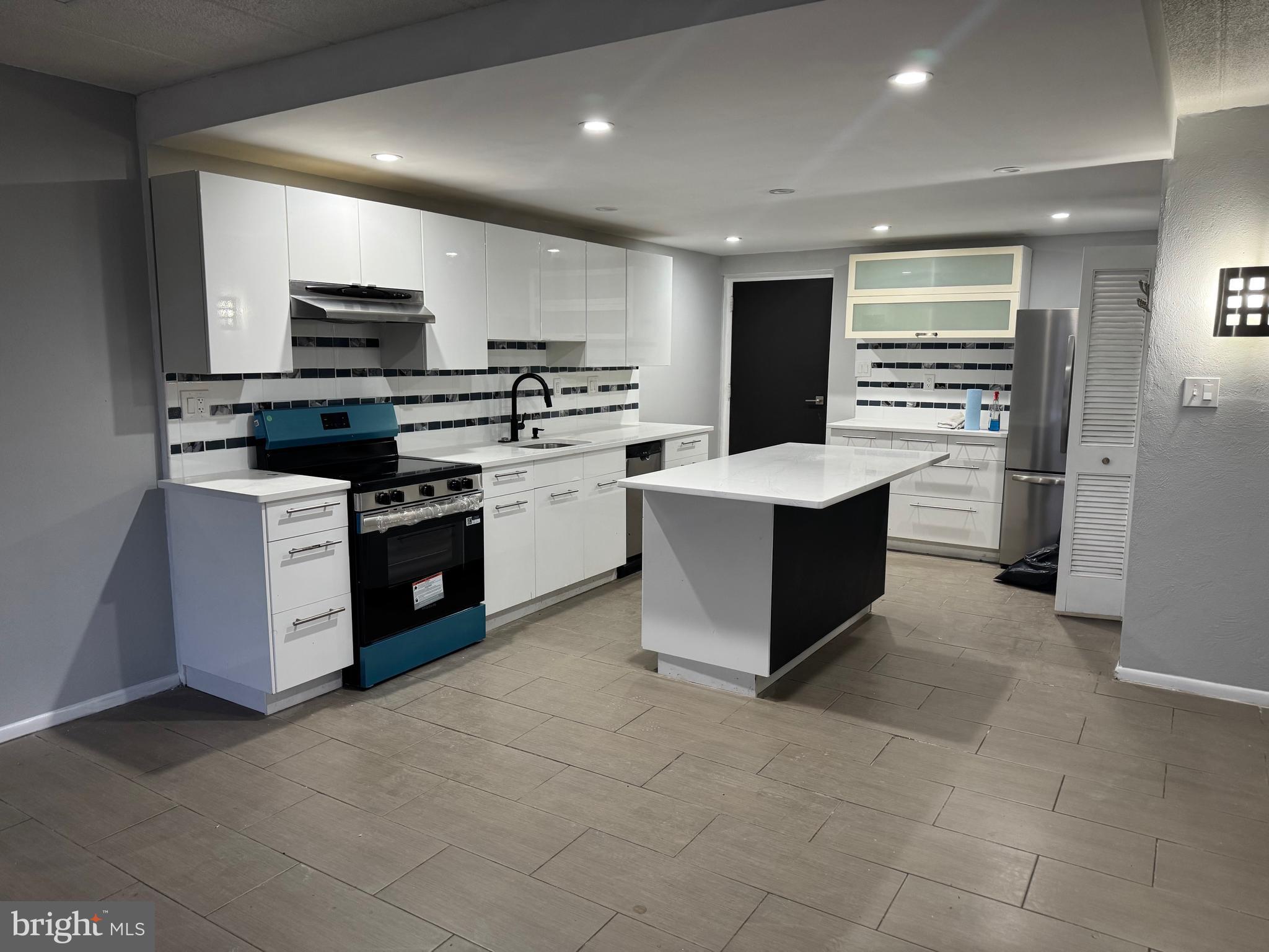 a kitchen with stainless steel appliances a stove sink microwave and cabinets