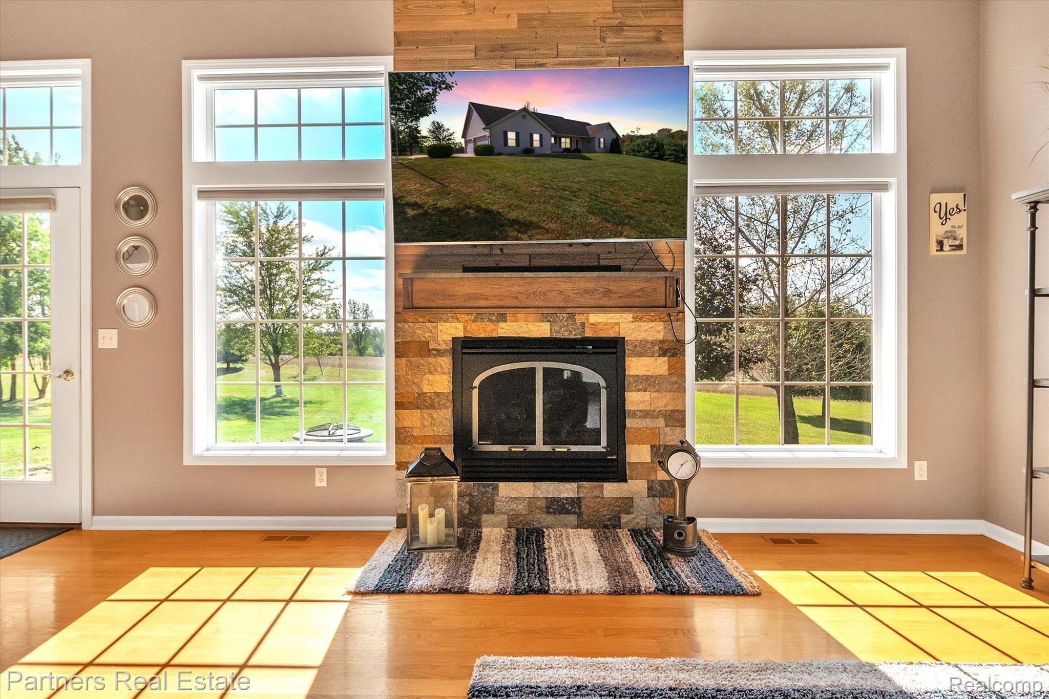 The stunning gas fireplace is framed in stone tile and shiplap and has a custom mantle with storage drawers on either side. 