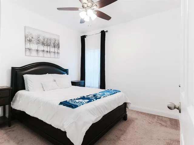 a bedroom with a bed and a painting on the wall