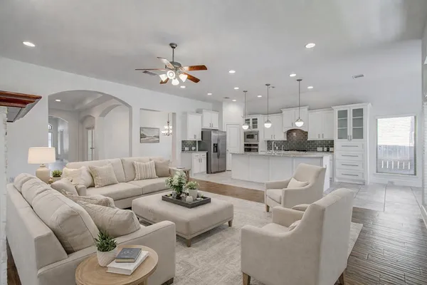 a living room with furniture kitchen and a chandelier
