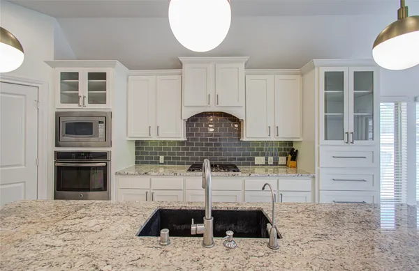 a kitchen with a sink a stove and cabinets