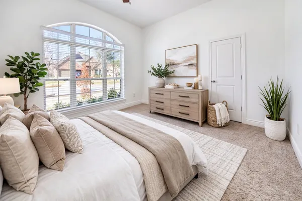 a bedroom with a bed and a large window