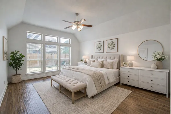 a spacious bedroom with a large bed and a chandelier