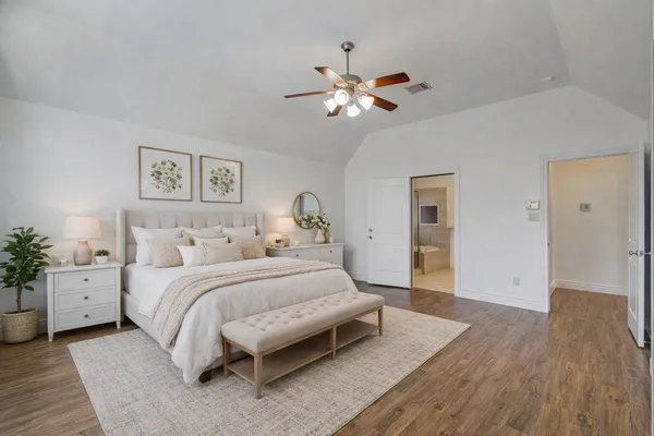 a bedroom with a large bed and a chandelier