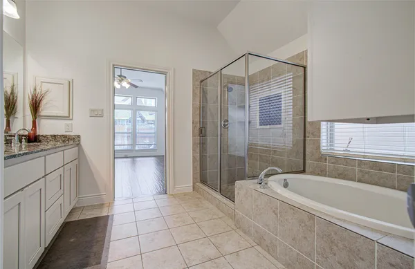 a bathroom with a granite countertop sink a mirror and a bathtub
