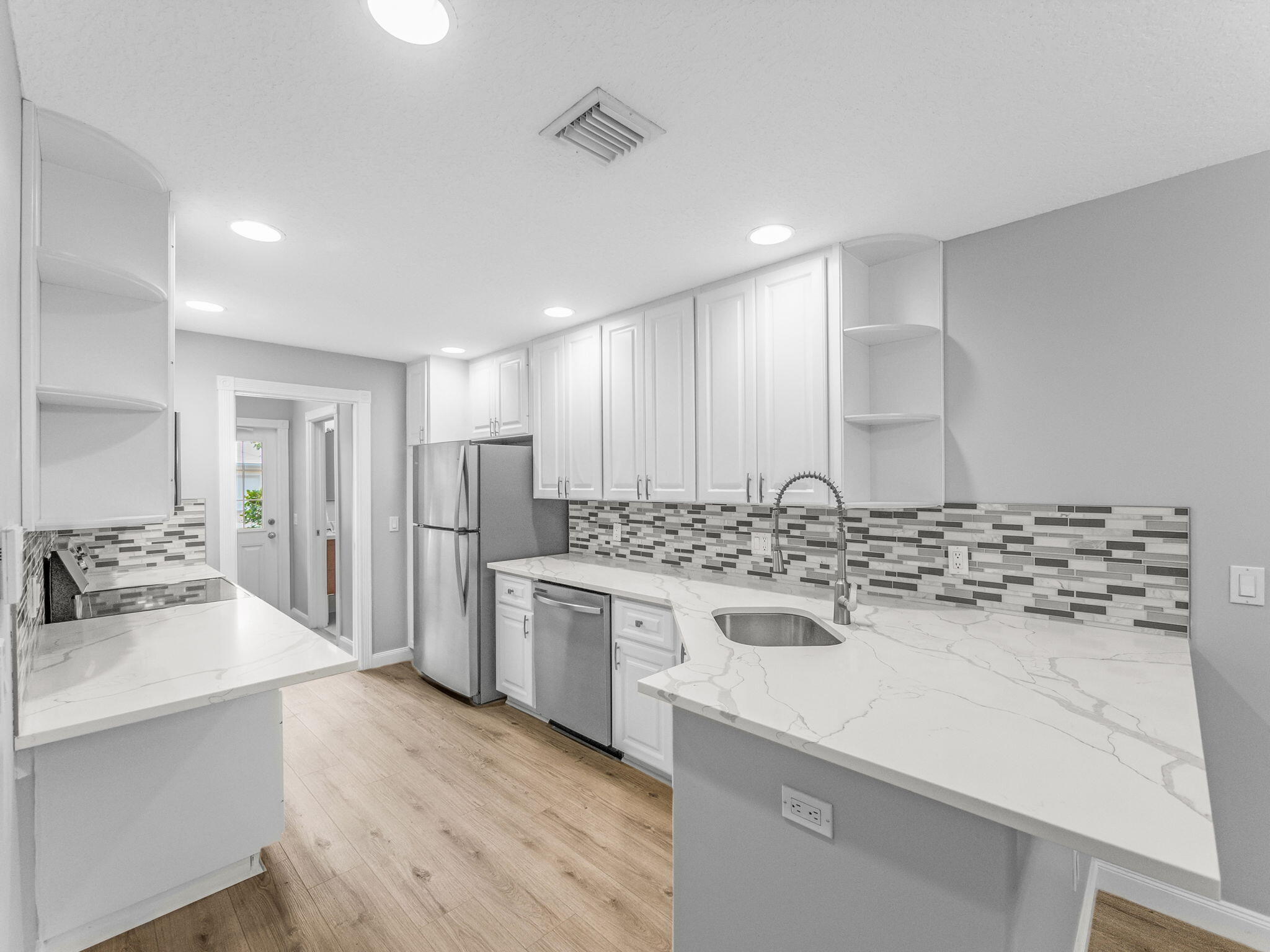 3119 East Community Drive Jupiter, FL 33458 - Photo 2 of 24 a kitchen with stainless steel appliances a sink stove and refrigerator