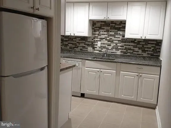 a kitchen with white cabinets and white appliances