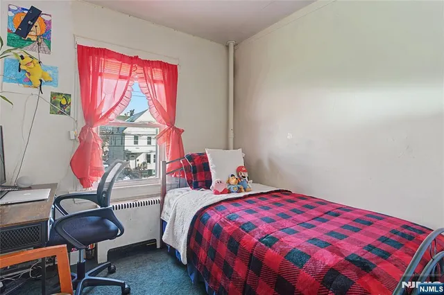 a bedroom with a bed a dresser and chair