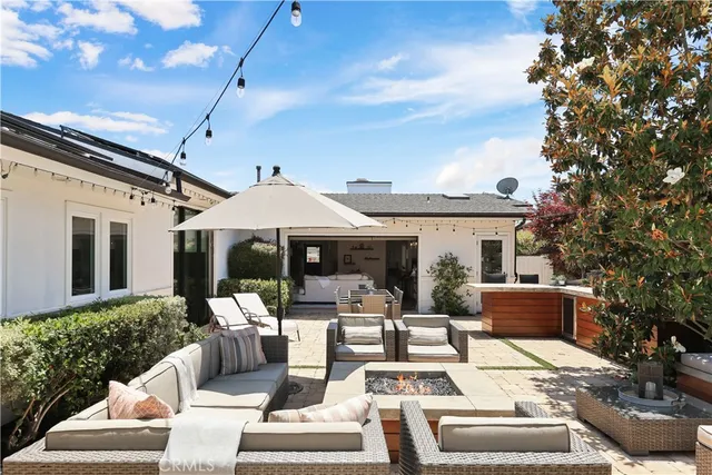 a view of a patio with couches table and chairs and potted plants