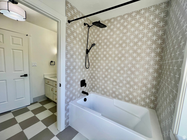 812 East Bates Cyn Road Tooele, UT 84074 - Photo 59 of 144 Bathroom featuring a white soaking tub with matte black fixtures, an accent wall with patterned tile, and checkered flooring
