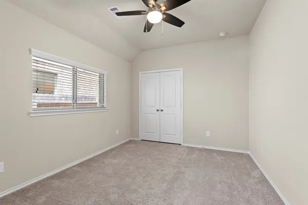 an empty room with windows and fan