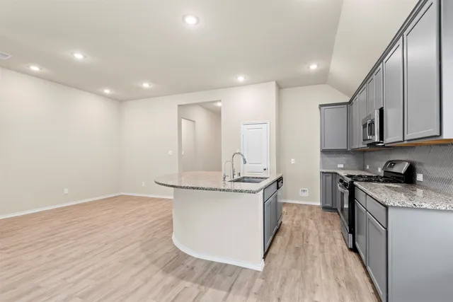 a kitchen with stainless steel appliances granite countertop a sink stove and refrigerator