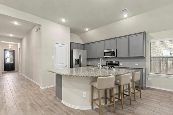 a kitchen with granite countertop a sink stove and cabinets