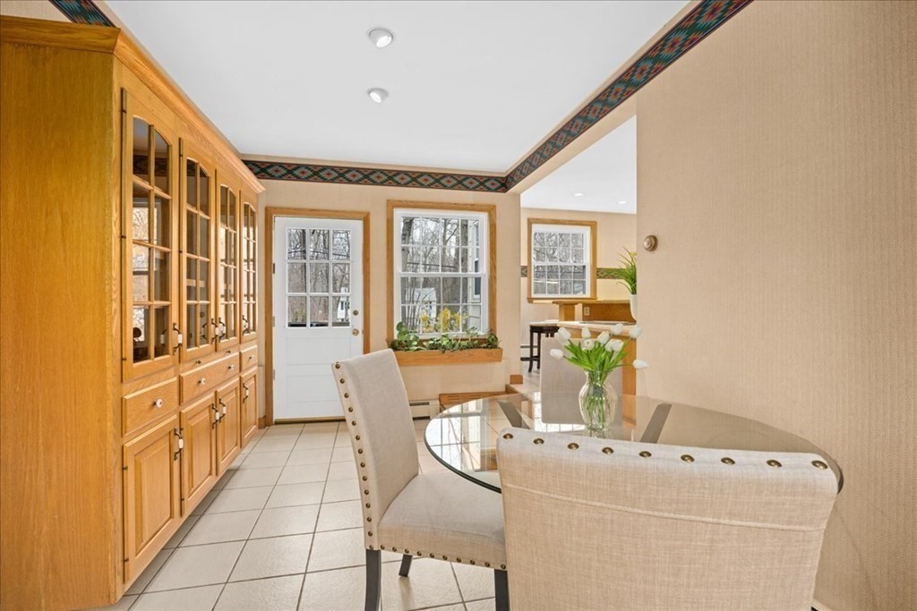 24 Oregon Road Ashland, MA 01721 - Photo 7 of 42 a dining room with furniture a flat screen tv and a potted plant