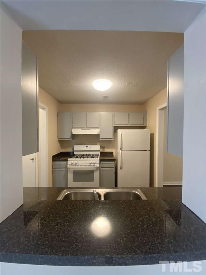 5820 Pointer Drive, Unit 202 Raleigh, NC 27609 - Photo 2 of 20 a kitchen with a refrigerator and a stove