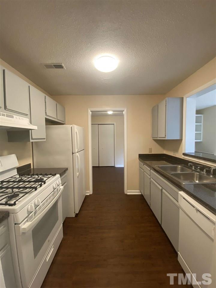 5820 Pointer Drive, Unit 202 Raleigh, NC 27609 - Photo 5 of 20 a kitchen with stainless steel appliances a stove a sink and a refrigerator