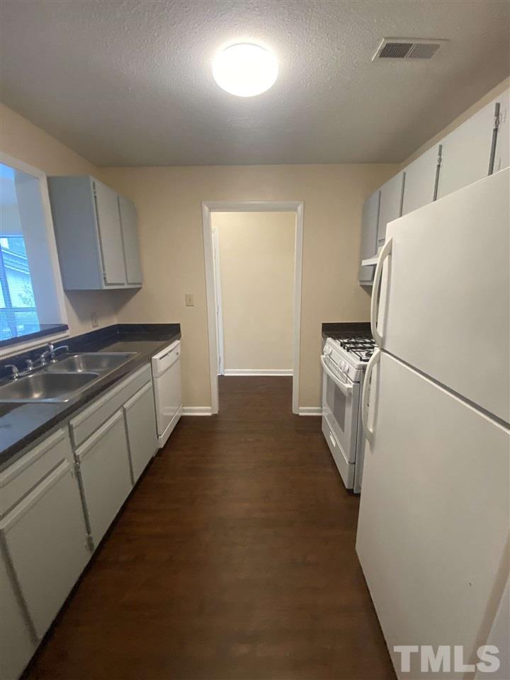5820 Pointer Drive, Unit 202 Raleigh, NC 27609 - Photo 9 of 20 a kitchen with a refrigerator a stove top oven and cabinets