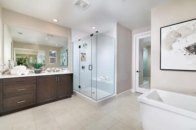 a bathroom with a tub sink shower and mirror