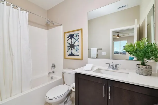 a bathroom with a sink a toilet a mirror a vanity and shower