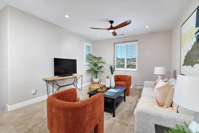 a living room with furniture a window and a flat screen tv