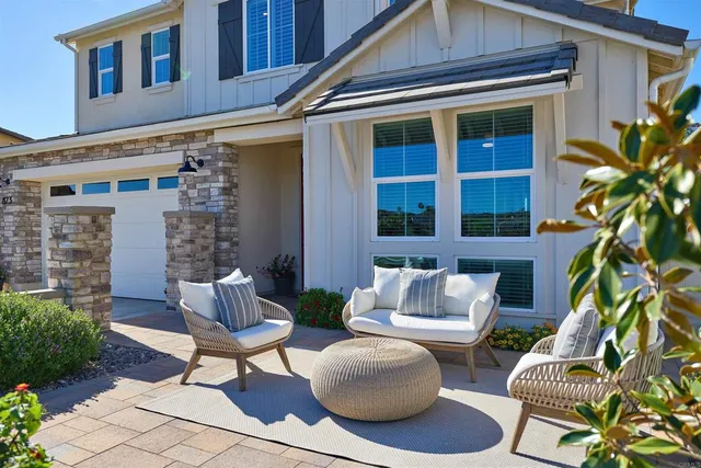 a view of a patio with couple of chairs and a potted plant