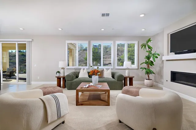 a living room with furniture a flat screen tv and a fireplace