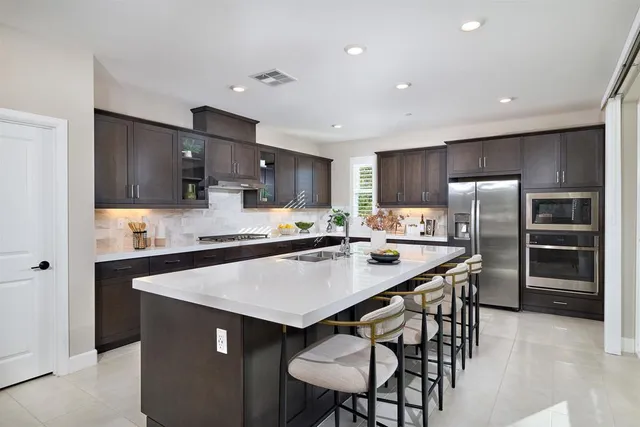 a kitchen with kitchen island a refrigerator stove microwave and cabinets