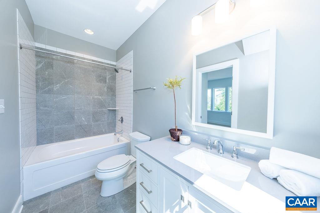 2399 Summit Ridge Trail Charlottesville, VA 22911 - Photo 45 of 54 a bathroom with a granite countertop sink toilet a large mirror a bathtub and shower