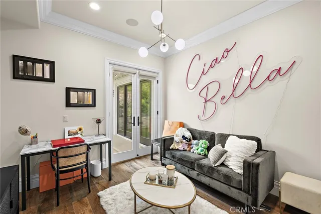 a living room with stainless steel appliances furniture a rug and a kitchen view