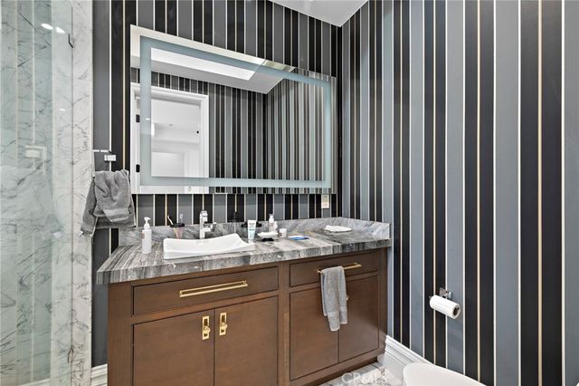 a spacious bedroom with a large bed a chandelier and windows