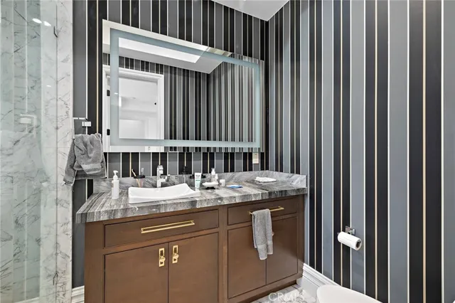 a spacious bedroom with a large bed a chandelier and windows