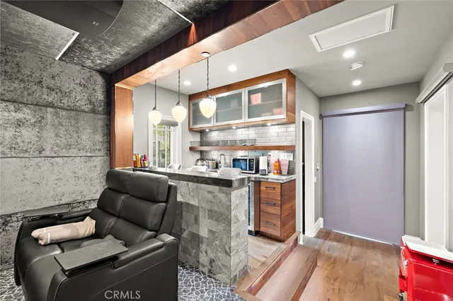a living room with furniture flat screen tv and kitchen view
