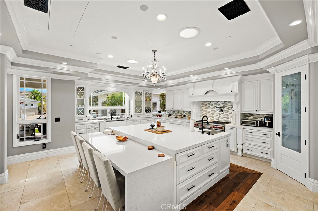 3202 Portico Del Norte San Clemente, CA 92673 - Photo 41 of 62 a large white kitchen with a stove a sink dishwasher and a dining table with wooden floor