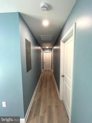 a view of an empty room with wooden floor and windows