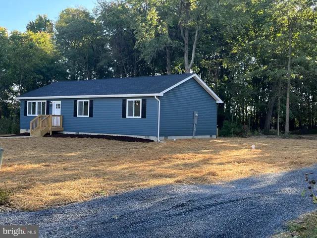 a view of a small house with wooden fence