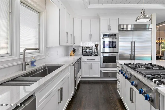 a kitchen with stainless steel appliances granite countertop table chairs stove and cabinets