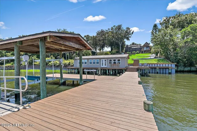 an aerial view of residential house with outdoor space and trees all around