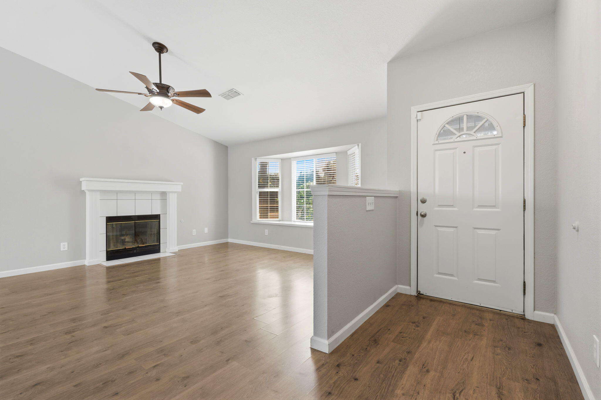 481 Katelyn Court Exeter, CA 93221 - Photo 6 of 33 an empty room with wooden floor fireplace and windows