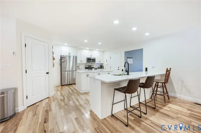 a kitchen with stainless steel appliances kitchen island granite countertop a sink and cabinets