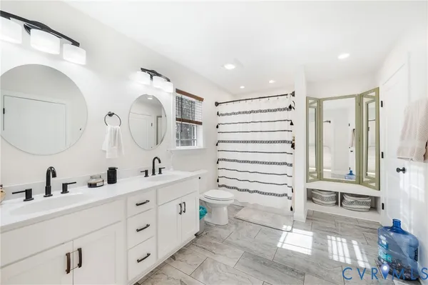 a bathroom with a double vanity sink mirror and shower