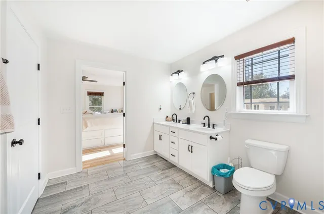 a bathroom with a sink mirror vanity and toilet