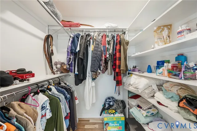 a view of walk in closet with clothes and shoes