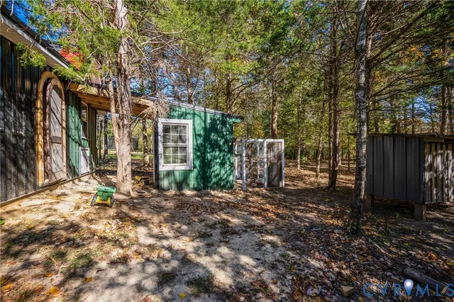 a view of a backyard with large trees and wooden fence