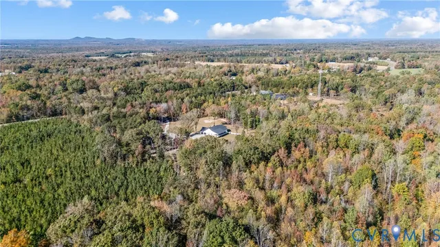 an aerial view of residential houses with outdoor space and trees