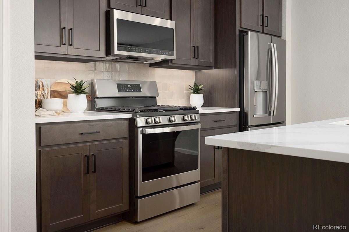 1717 Bloom Street Brighton, CO 80601 - Photo 9 of 11 a kitchen with stainless steel appliances granite countertop a stove and a microwave