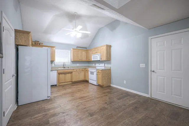 a kitchen with a refrigerator sink and cabinets